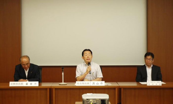 挨拶をする井崎社会部会長、写真左は相川文教部会長、右は厚生労働省岡田社会・援護局長